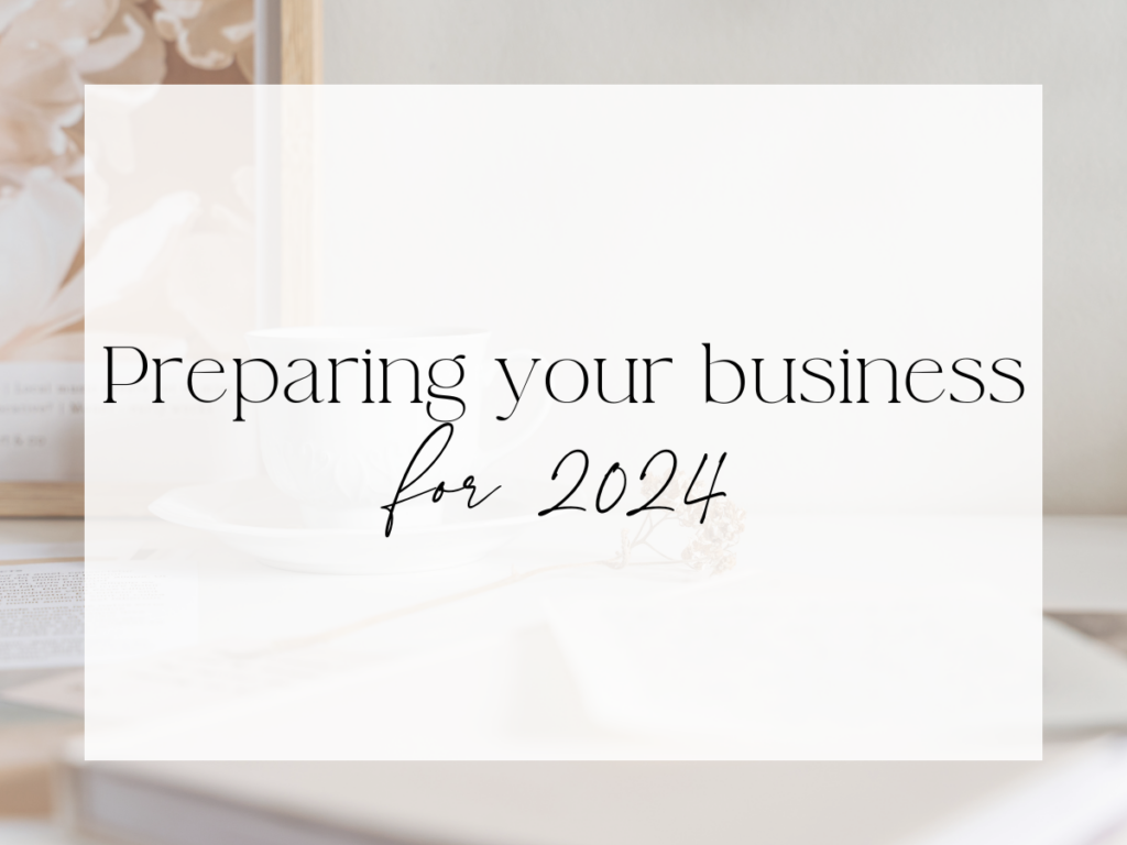 Soft, neutral workspace scene with a coffee cup and books in the background. Over a white overlay, the text reads: “Preparing your business for 2024.”